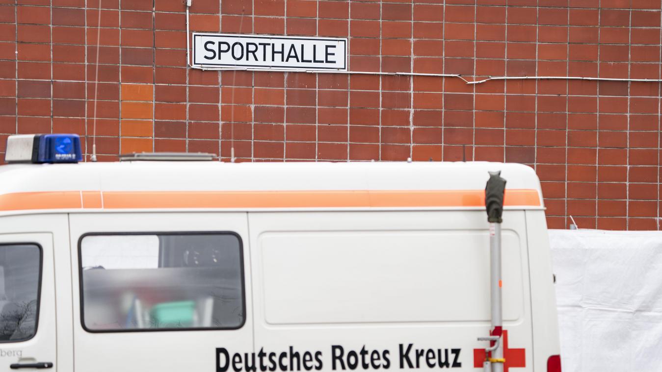 <p>Ein Fahrzeug des Roten Kreuzes steht vor einer Sporthalle. Der von der Ausbreitung des Coronavirus besonders betroffene Kreis Heinsberg hatte am Montag eine zentrale Anlaufstelle zur Probenentnahme bei Patienten mit Coronavirus-Verdacht in einer Halle in der Nähe von Gangelt eröffnet.</p>