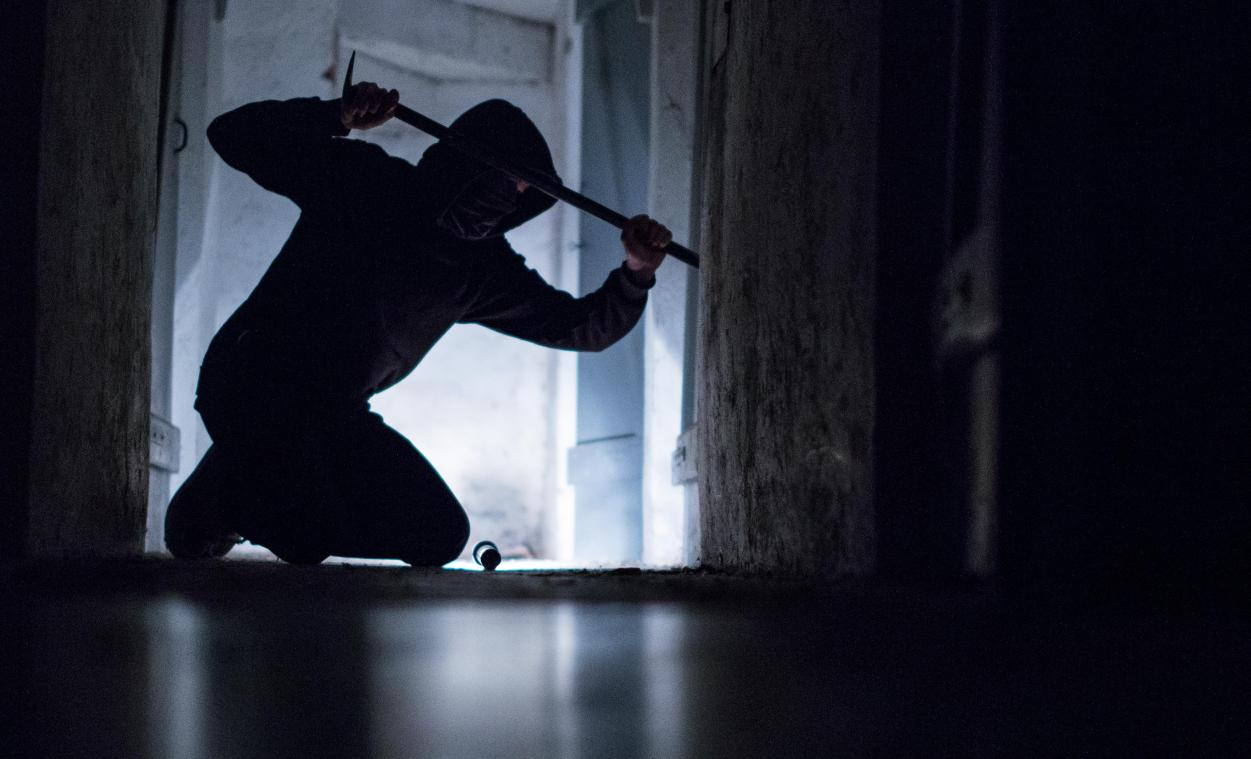 <p>Ein fiktiver Einbrecher hebelt mit einem Brecheisen eine Tür im Keller eines Wohnhauses auf.</p>