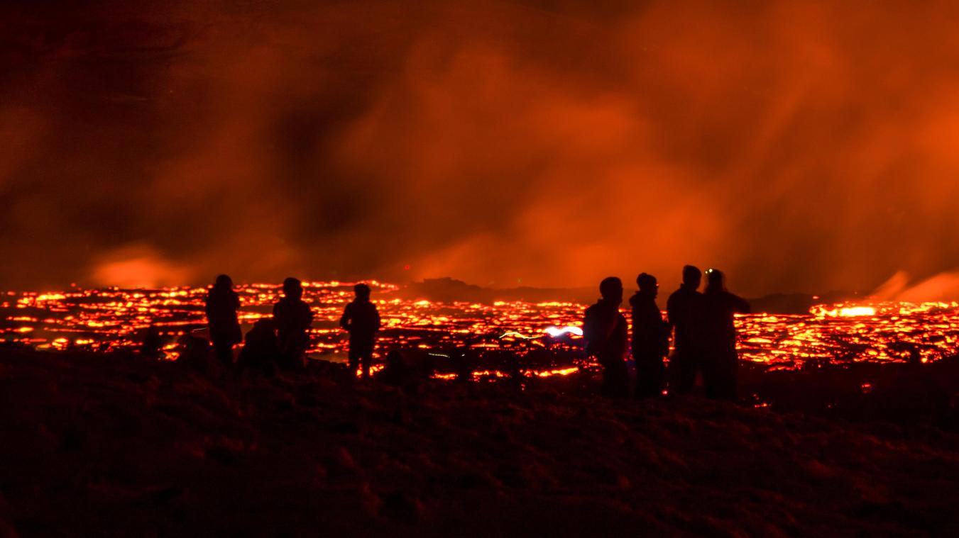 <p>Menschen beobachten die Lava des Vulkans nach dessen Ausbruch auf der Halbinsel Reykjanes im Südwesten Islands</p>