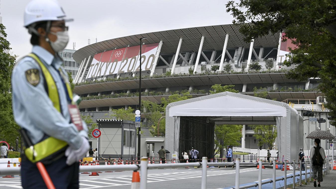 <p>Ein Sicherheitsbeamter trägt eine Schutzmaske und steht vor dem Nationalstadion. Während der Olympischen Spiele soll in Tokio erneut der Corona-Notstand herrschen.</p>