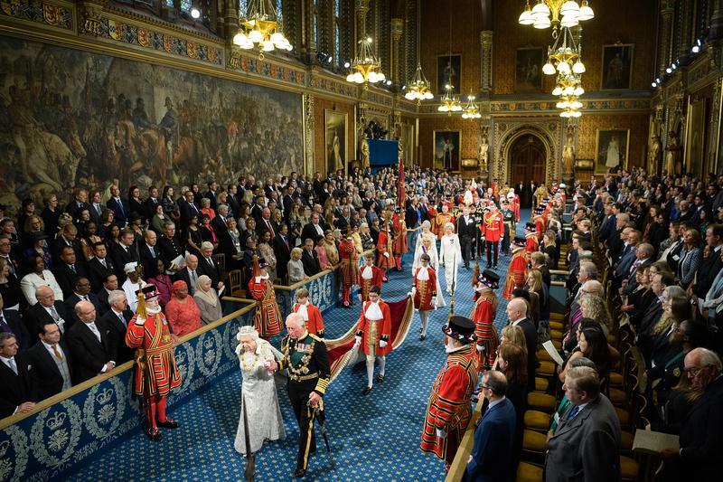 <p>Königin Elizabeth II. (l.), wird von Prinz Charles begleitet, als sie durch die Royal Gallery geht, bevor sie die sogenannte „Queen's Speech“ während der feierlichen Wiedereröffnung des britischen Parlaments im House of Lords im Westminster-Palast hält.</p>