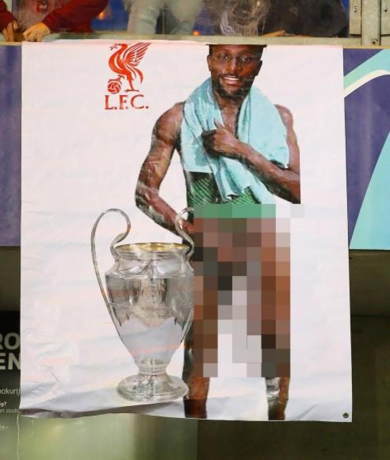 <p>In Genk hingen Zuschauer ein geschmackloses Plakat voller rassistischer Vorurteile auf, das Liverpool-Profi Divock Origi auf einer Fotomontage zeigt.</p>