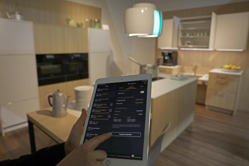<p>Auf der IMM Cologne steht neben dem smarten Wohnen – hier ist zu sehen, wie eine Frau mit dem iPad eine Küche im Ausstellungsbereich Smart Village steuert.</p>