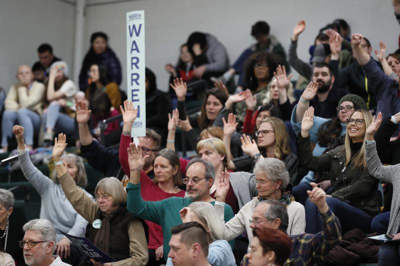 <p>Unterstützer der demokratischen Präsidentschaftskandidatin Warren heben zur Auszählung während einer demokratischen Parteiversammlung in der Hoover High School ihre Hand.</p>
