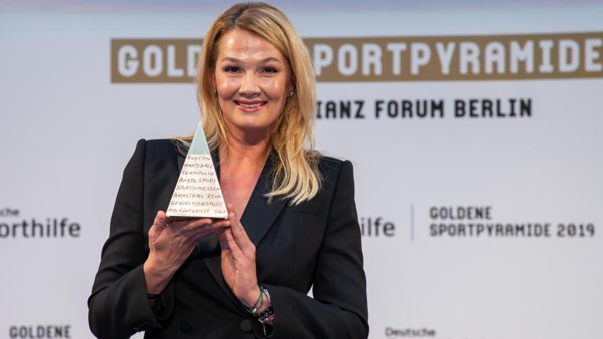 <p>Franziska von Almsick hält die an sie verliehene „Goldene Sportpyramide“ in der Hand.</p>