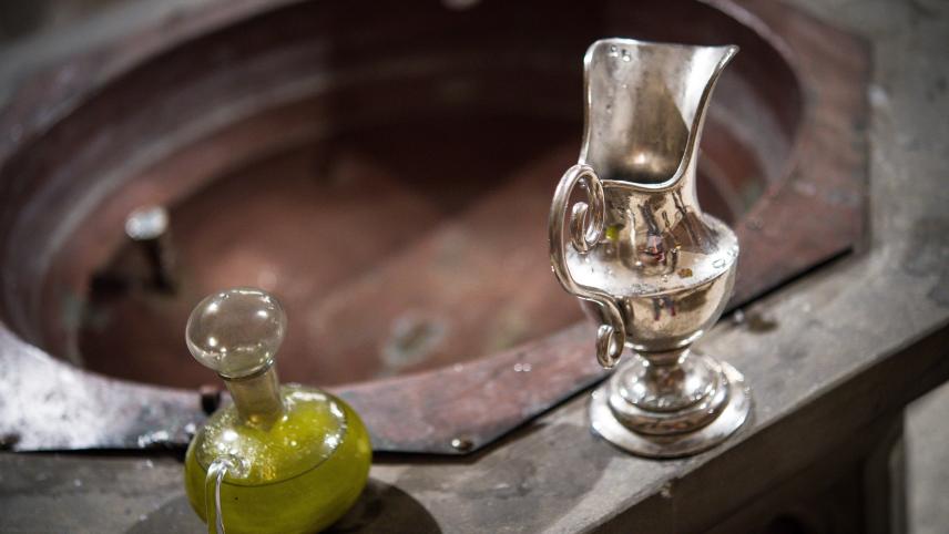 <p>Eine Wasserkaraffe und Chrisamöl in einem Glasflakon stehen am Rande eines Taufbeckens für eine Taufe bereit: In Belgien findet in den katholischen Gotteshäusern vermehrt weniger Tauffeiern statt.</p>